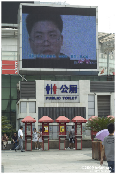 How appropriate, a mega video screen, public toilet and phone booth in a compact space.